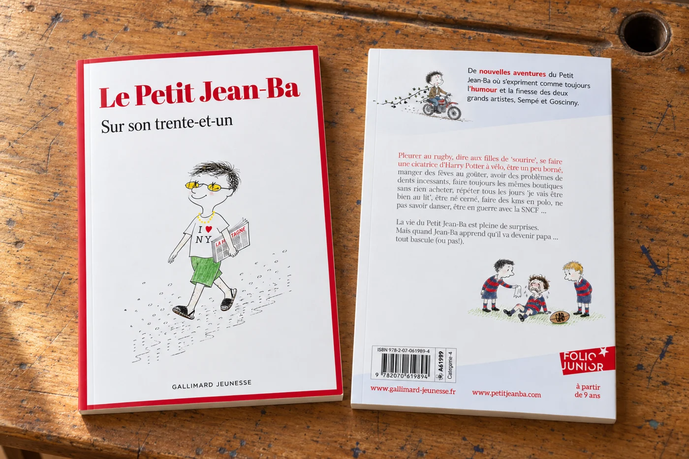 Le Petit Jean-Ba, couverture et quatrième de couverture posées sur un bureau en bois